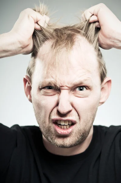 Homem caucasiano arrancando cabelo com frustração — Fotografia de Stock