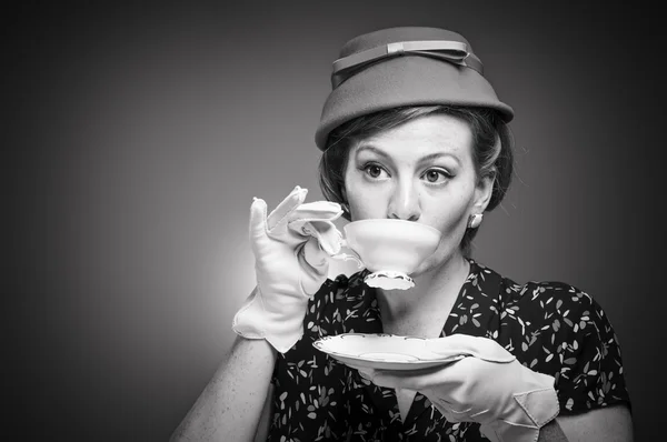 Retro vrouw haar thee drinken — Stockfoto