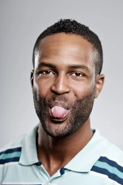 Hombre afroamericano sacando su lengua — Foto de Stock