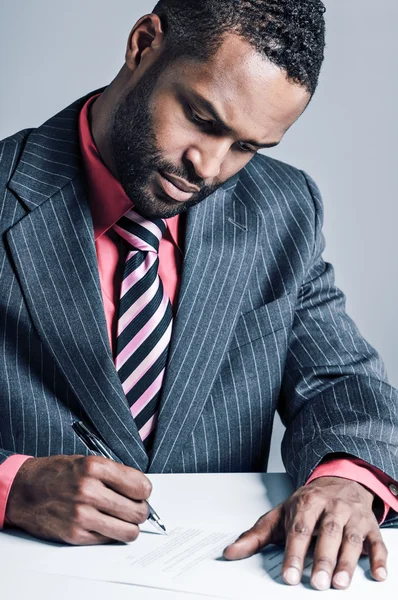 Афроамериканский бизнесмен подписывает контракт — стоковое фото