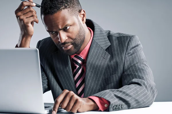 Joven hombre de negocios afroamericano usando computadora portátil —  Fotos de Stock