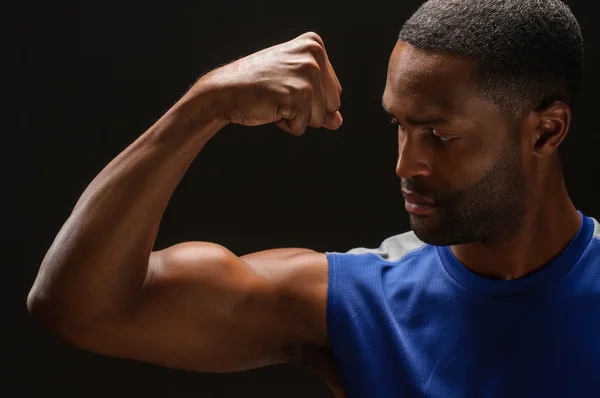 Joven afroamericano hombre Flexing bíceps —  Fotos de Stock