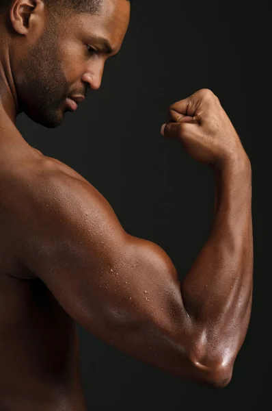 Mladý Američan Afričana muž protahuje biceps — Stock fotografie