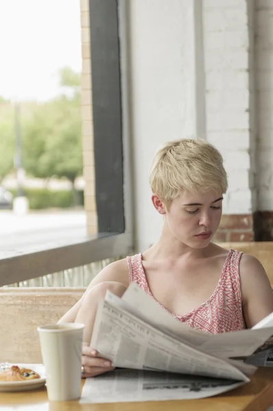 Kobieta czytanie gazety w kawiarni — Zdjęcie stockowe