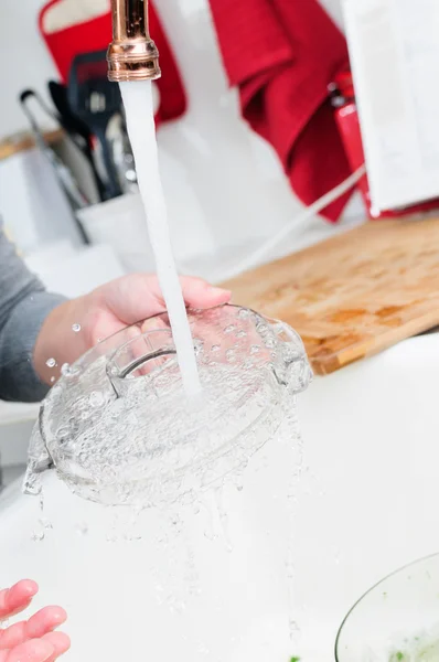 Женщина моется в раковине на кухне — стоковое фото