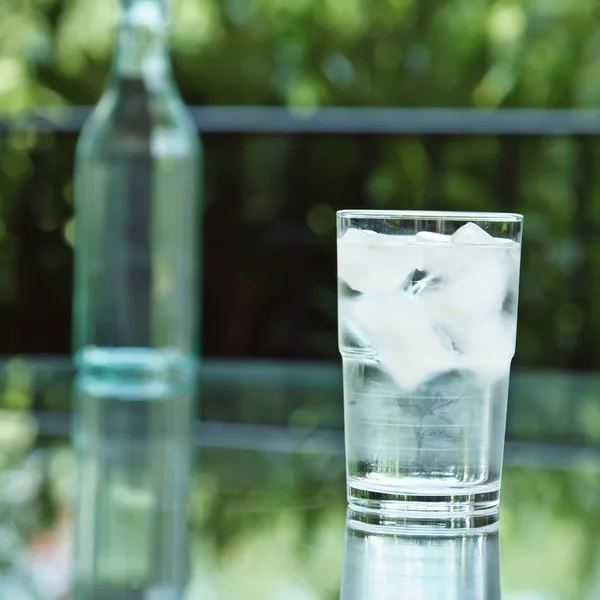 A glass of ice water on the patio. — Stock Photo, Image