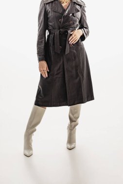 Son moda sokak tarzı detaylar. Yakın plan, deri çukur sıska bir kız ve bej renkli eski botlar.