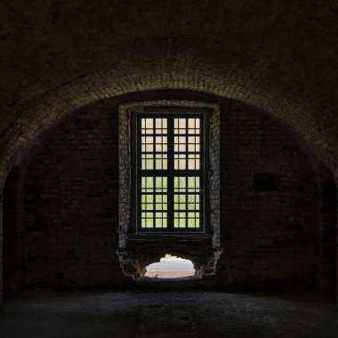 Slovakya 'nın Komarno kentindeki eski bir kalenin parmaklıklı penceresinden bir odanın içine bak.