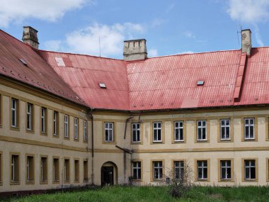 Slovakya, Komrno 'daki eski kalede kırmızı teneke çatısı ve üç bacası olan terk edilmiş bir bina.