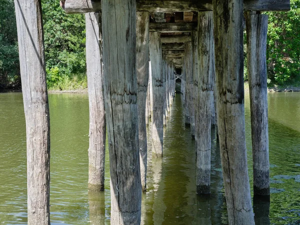 Dřevěné Pilíře Pod Mostem Přes Řeku — Stock fotografie