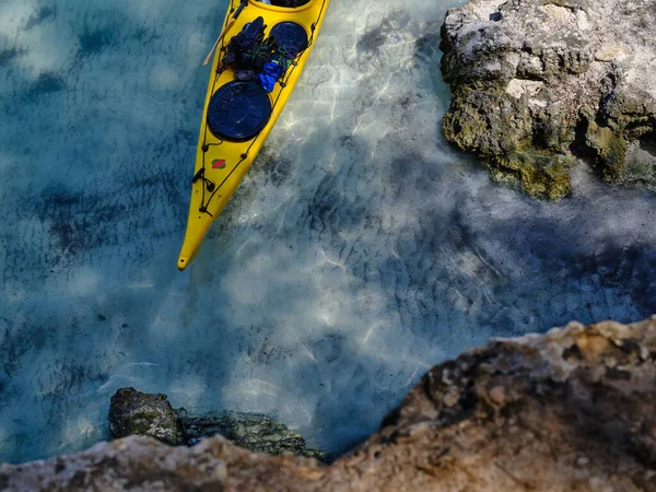 Yellow sea kayak ready on the sea by the rock