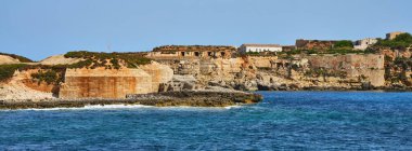 Panorama of the coast of the island of Menorca with a ruined old fortification, Spain