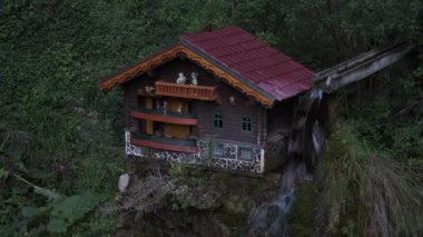 Hareket eden figürleri ve su değirmeni olan küçük ev modeli