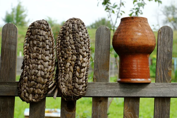 Valla decoración bast zapatos y jarra de leche — Foto de Stock