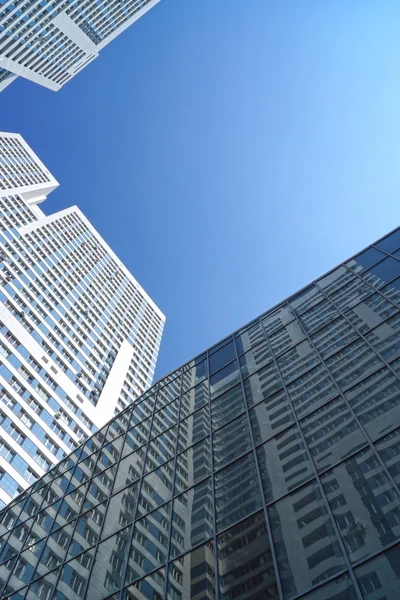 Высотное отражение здания в зеркальном фасаде офисного здания — стоковое фото