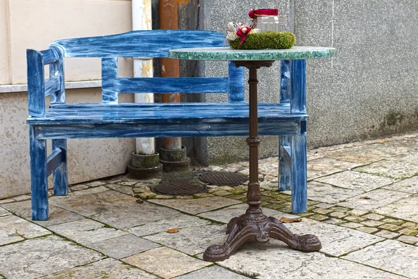 Banc bleu et une table devant un café — Photo