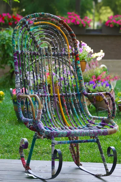 Крісло-качалка в саду з квітами — стокове фото