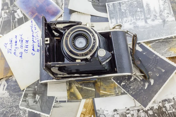 Ретро-камера на фоне старых фотографий — стоковое фото