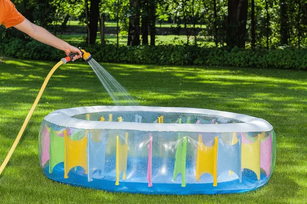 Filling a pool with gared hose — Stock Photo, Image