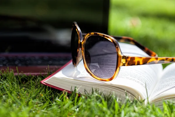 Zonnebrillen en boek — Stockfoto