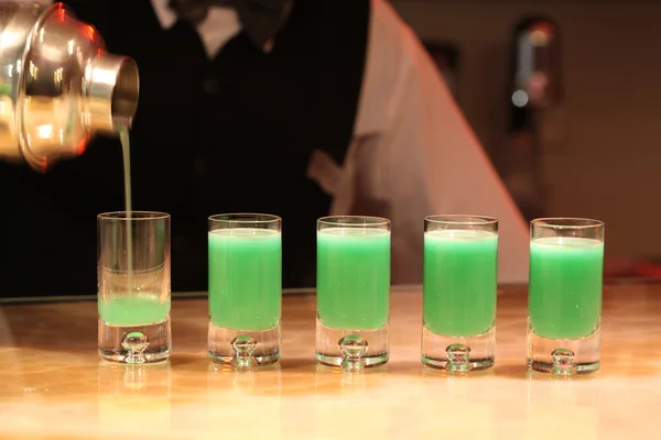 Barman servindo tiros de álcool verde . — Fotografia de Stock