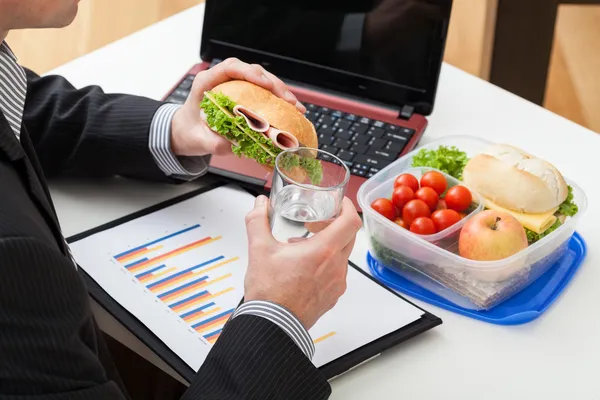 Manager isst während der Arbeit ein Sandwich — Stockfoto