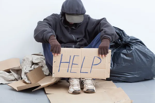 Бездомний чоловік сидить на вулиці — стокове фото