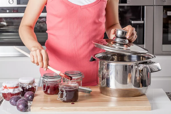 Husmor som lager plommesyltetøy – stockfoto