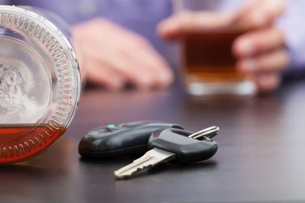 Arabanın anahtarları yanında şişe alkol — Stok fotoğraf