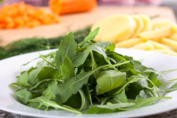 Green arugula placed on white plate — Stock Photo, Image