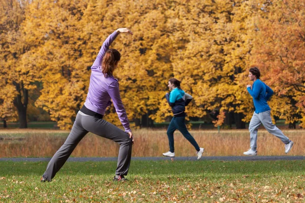 Mladí lidé cvičení v parku — Stock fotografie