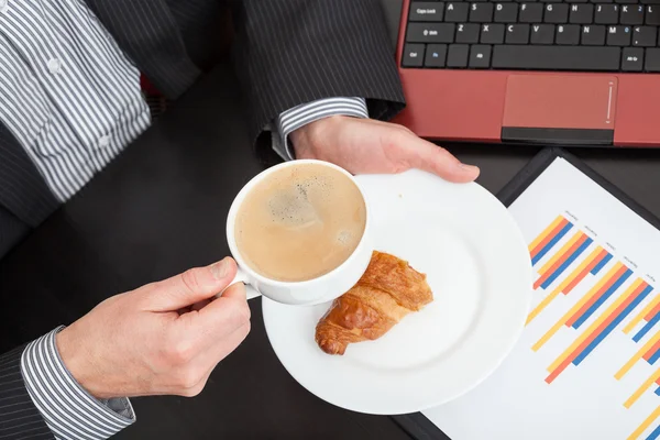 Businessman with snack and coffee — Stock Photo, Image