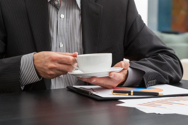 Empresário segurando uma xícara de café — Fotografia de Stock