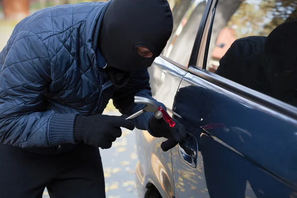 Breaking into a car with hammer — Stock Photo, Image
