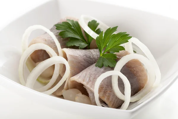 Herrings with sliced onion in white bowl — Stock Photo, Image