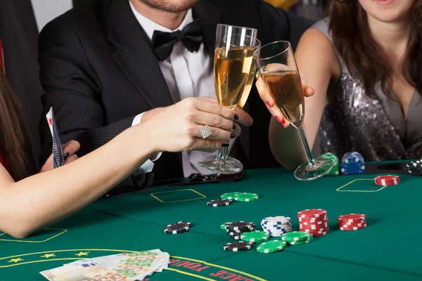 Vrienden in casino van het verhogen van een bril — Stockfoto
