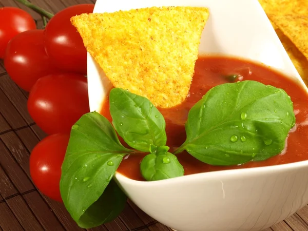 Molho de salsa com nachos mergulhados — Fotografia de Stock