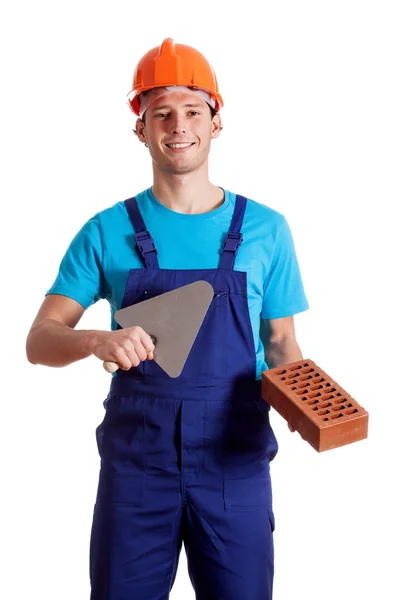 Young constructor with putty knife and brick — Stock Photo, Image