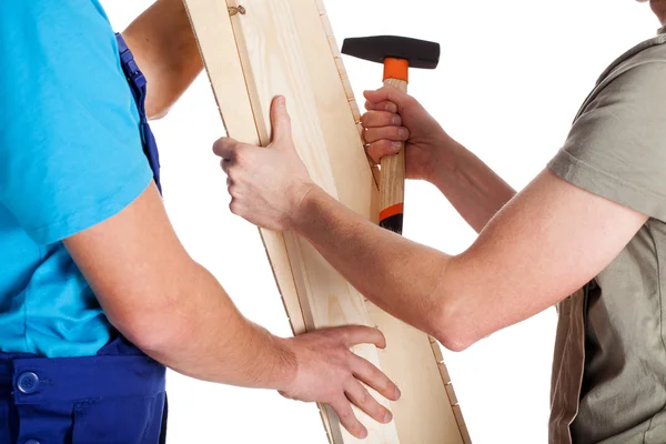 Twee mannen met plank en hamer — Stockfoto