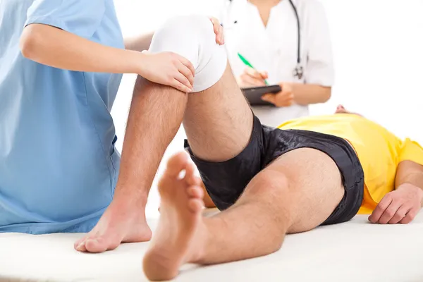 Equipo médico examinando condición de rodilla — Foto de Stock