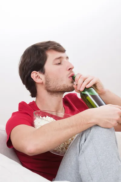 Homem bebendo cerveja em um sofá — Fotografia de Stock