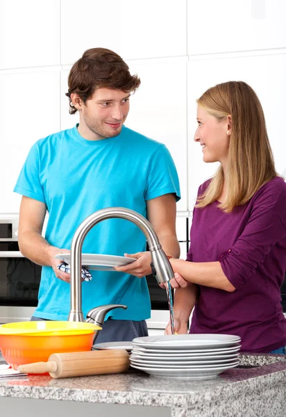 Young man helping his wife in household — Stock Photo, Image