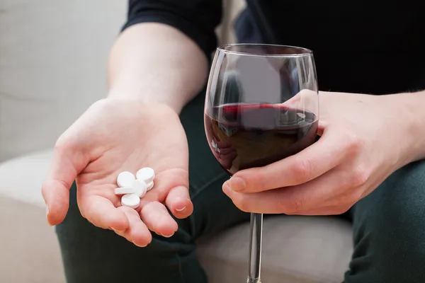 Femme prenant des analgésiques et l'alcool — Photo