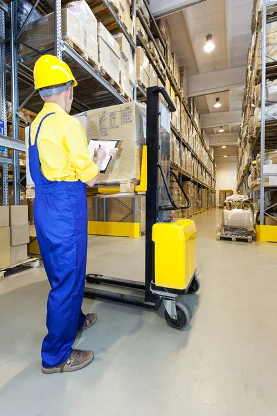 Worker checking products in warehouse — Stock Photo, Image