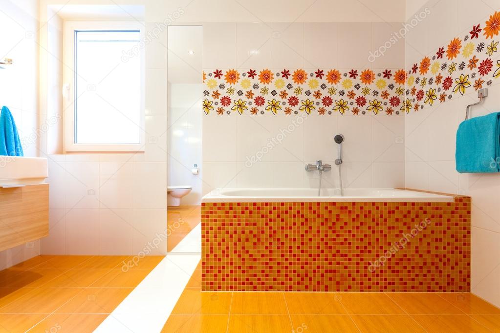 Big orange bath in cute contemporary bathroom