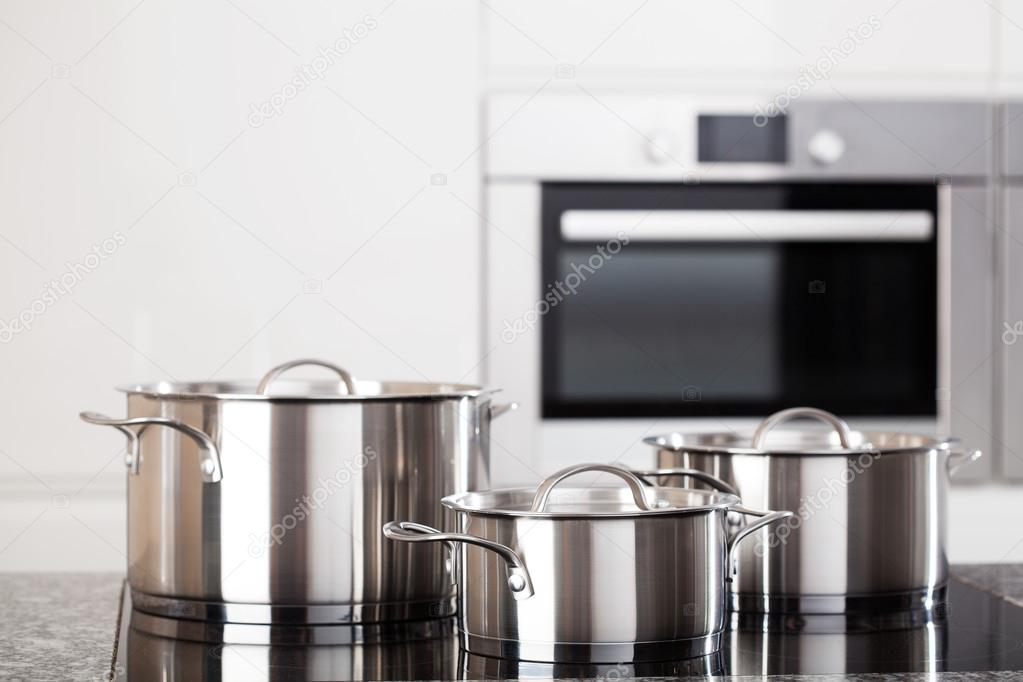 Three metal pots on induction hob