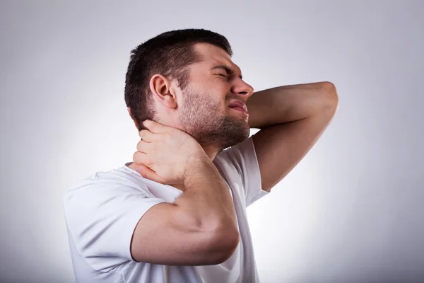 Junger Mann mit Nackenschmerzen — Stockfoto