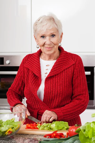 Gelächelte Frau bereitet Mahlzeit zu — Stockfoto