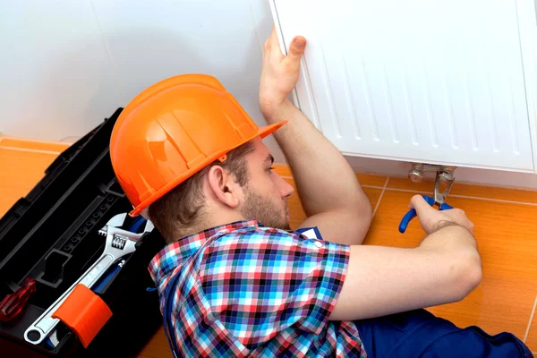 Homem útil reparando aquecedor — Fotografia de Stock