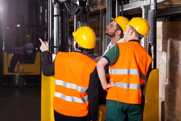 Operaio su carrello elevatore in magazzino — Foto Stock